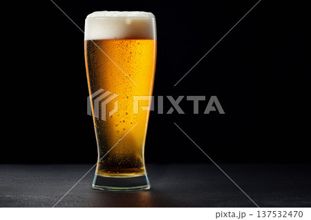 Glass of craft amber beer with foam on black backdrop, concept of refreshment and taste feel Glass of craft amber beer with foam on black backdrop, concept of refreshment and taste feel 137532470