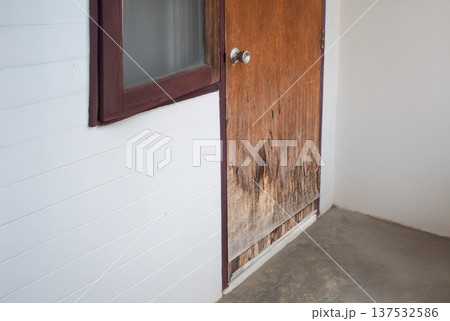 Improper use a plywood door for exterior is swollen and damaged by humidity in the rainy season. Improper use a plywood door for exterior is swollen and damaged by humidity in the rainy season. 137532586