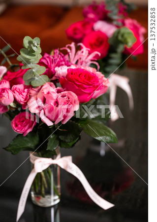 Pink rose bouquet with eucalyptus in glass vase on dark reflective surface 137532858