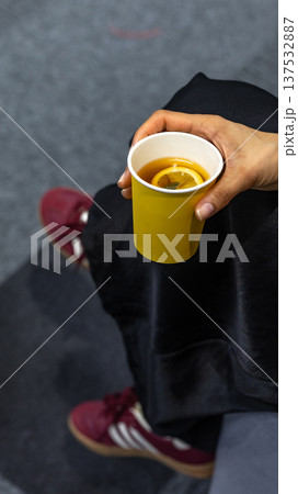 Hand Holding Yellow Paper Cup with Hot Lemon Tea Hand Holding Yellow Paper Cup with Hot Lemon Tea 137532887