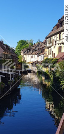 Phone photo of the canal in Little Venice in Colmar with lush spring greenery. Scenic riverside view showing historic architecture, nature, and calm seasonal atmosphere. Phone photo of the canal in Little Venice in Colmar with lush spring greenery. Scenic riverside view showing historic architecture, nature, and calm seasonal atmosphere. 137532910