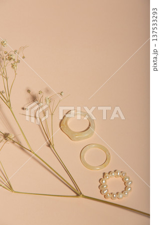 Sophisticated Arrangement Of Resin Rings And Pearls On Muted Pastel Surface Emphasizes Minimalist Elegance 137533293