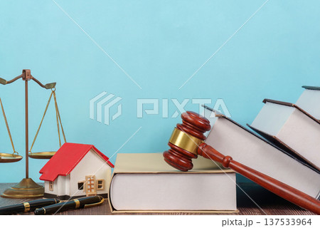 Legal Background with Scales and House Model. A lawyer's desk featuring law books and a gavel. 137533964