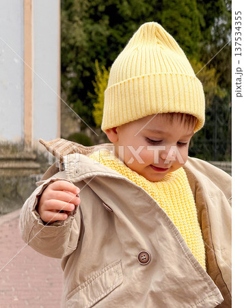 Toddler Taking First Steps Outdoors in Yellow Knit Hat 137534355