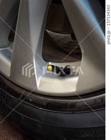 Car wheel close-up with tire valve stem and pressure cap Car wheel close-up with tire valve stem and pressure cap 137534365