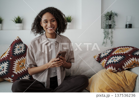 Content Female Individual Relaxing In Cozy Setting With Decorative Cushions And Lush Indoor Plants 137536236