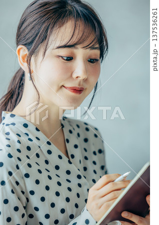 手帳を持つ若い女性 137536261