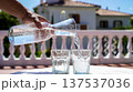 Pouring Sparkling Water Into Glasses on Terrace 137537036