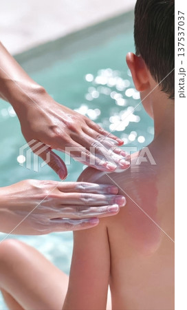 Applying Sunscreen to Child by Poolside 137537037
