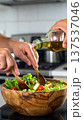 Pouring Olive Oil Over Fresh Green Salad 137537046