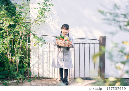 庭で野菜を持っている女の子 137537439