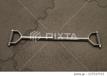 Metal bar handle on asphalt surface with grips 137537531