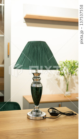 Elegant green lampshade on polished metal base in modern interior setting 137537558