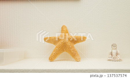 Starfish and buddha statue on minimalist shelf decor Starfish and buddha statue on minimalist shelf decor 137537574