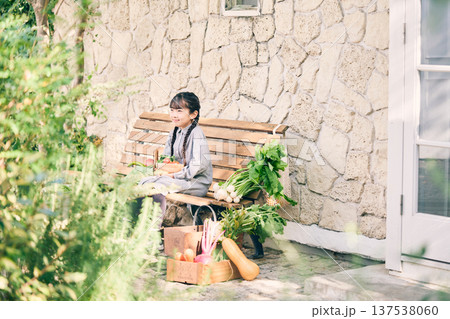野菜を持ってベンチに座っている女の子 137538060
