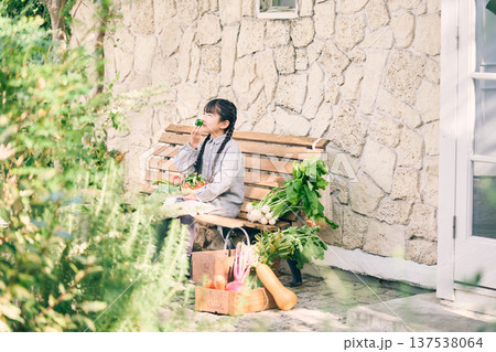 野菜を持ってベンチに座っている女の子 137538064