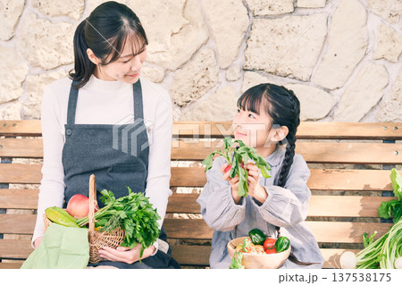 野菜を持ってベンチに座っている親子 137538175