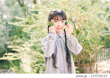 庭で野菜を持っている女の子 137538214