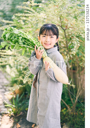 庭で大根を持っている女の子 137538234
