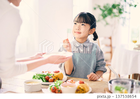 食事の手伝いをする女の子 137538654
