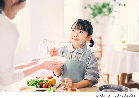 食事の手伝いをする女の子 137538658