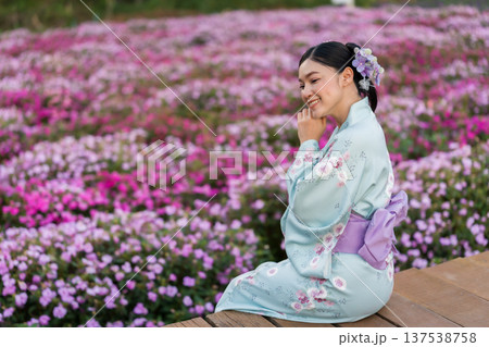 woman in yukata (kimono dress) with flower blooming in garden 137538758