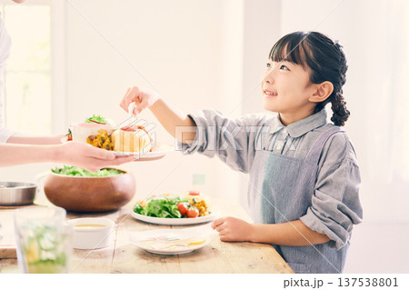 食事の準備の手伝いをする女の子 137538801