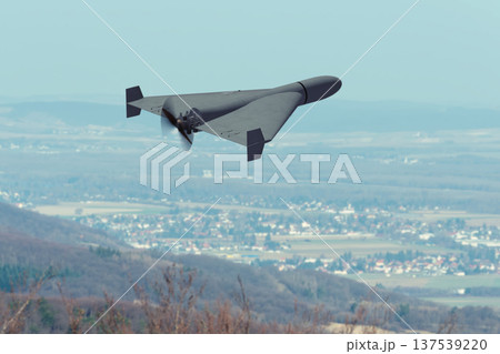 Kamikaze attack drone flies above rural landscape during war. Kamikaze attack drone flies above rural landscape during war. 137539220