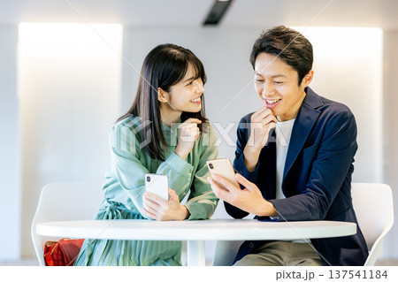 スマホで検索する若い夫婦 137541184