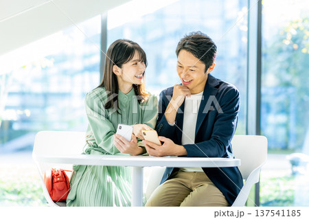 スマホで検索する若い夫婦 137541185