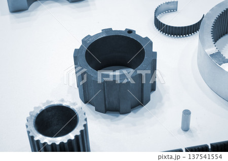 Different metal models on a white surface. Many metal products close-up. Various metal parts of gear transmissions. Gear wheels. Metal processing. Industrial metalworking objects. Steel manufacturing 137541554
