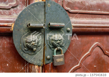 Traditional chinese door with lion-head handles and padlock Traditional chinese door with lion-head handles and padlock 137541610