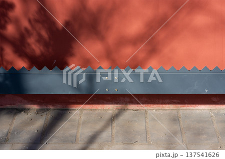 Red Wall With Corrugated Metal Edge and Tree Shadows Red Wall With Corrugated Metal Edge and Tree Shadows 137541626