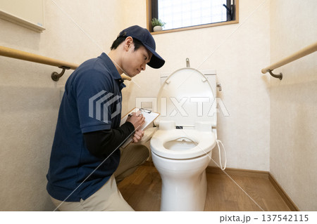 トイレのリフォームの見積もりをする男性 トイレのリフォームの見積もりをする男性 137542115