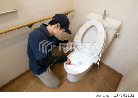 ペンライトを使ってトイレの清掃をする男性 137542132
