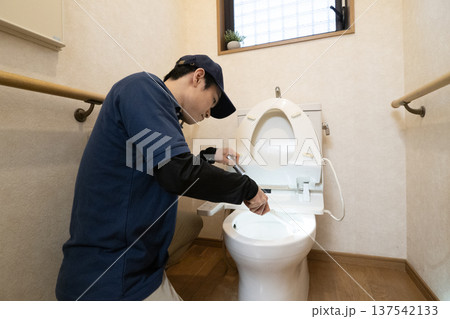 ペンライトを使ってトイレの清掃をする男性 ペンライトを使ってトイレの清掃をする男性 137542133