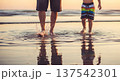 Father and child splashing water and walking in shallow sea at sunset for summer background and banner design 137542301