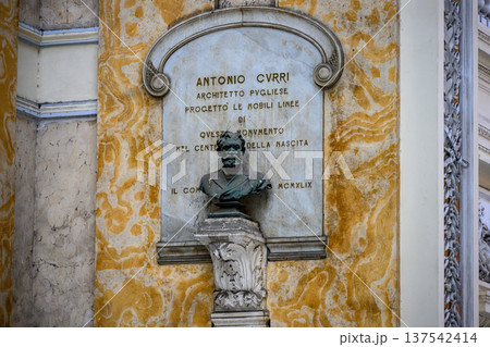 Marble memorial plaque featuring a bust of a man,likely Antonio Curri,located within Galleria Umberto I,Naples,Italy.The plaques inscription honors Curri and mentions his architectural contributions. Marble memorial plaque featuring a bust of a man,likely Antonio Curri,located within Galleria Umberto I,Naples,Italy.The plaques inscription honors Curri and mentions his architectural contributions. 137542414