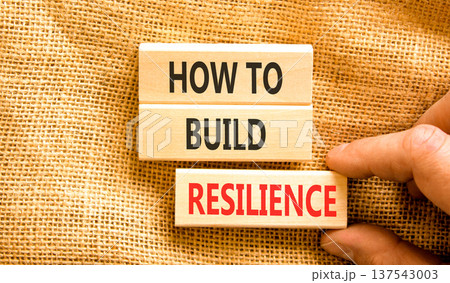 How to build resilience symbol. Concept words How to build resilience on beautiful wooden blocks. Beautiful canvas background. Businessman's hand. Business how to build resilience concept. Copy space 137543003