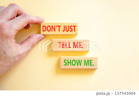 Tell or show symbol. Concept words Do not just tell me, show me on beautiful wooden blocks. Beautiful white background. Businessman's hand. Business tell or show concept. Copy space. 137543004