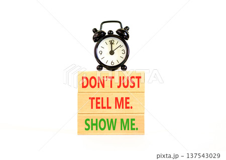 Tell or show symbol. Concept words Do not just tell me, show me on beautiful wooden blocks. Beautiful white background. Black alarm clock. Business tell or show concept. Copy space. 137543029