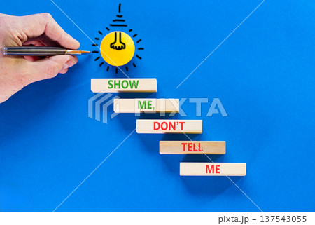 Tell or show symbol. Concept words Show me, do not tell me on beautiful wooden blocks. Beautiful blue paper background. Light bulb icon. Businessman hand. Business tell or show concept. Copy space. Tell or show symbol. Concept words Show me, do not tell me on beautiful wooden blocks. Beautiful blue paper background. Light bulb icon. Businessman hand. Business tell or show concept. Copy space. 137543055