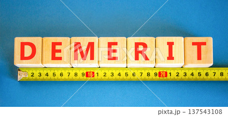 Demerit symbol. Concept word Demerit on beautiful wooden blocks. Beautiful blue background. Beautiful yellow ruler. Business demerit concept. Copy space. Demerit symbol. Concept word Demerit on beautiful wooden blocks. Beautiful blue background. Beautiful yellow ruler. Business demerit concept. Copy space. 137543108