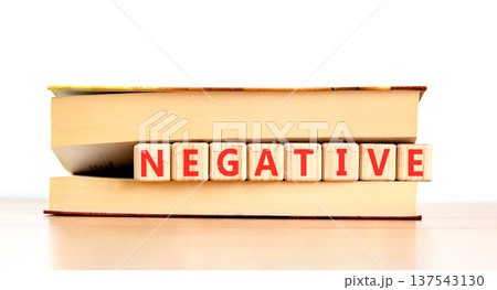 Negative word symbol. Concept word Negative on beautiful wooden blocks in beautiful book. Beautiful wooden table white background. Business support help negative word concept. Copy space. Negative word symbol. Concept word Negative on beautiful wooden blocks in beautiful book. Beautiful wooden table white background. Business support help negative word concept. Copy space. 137543130