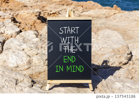 Start with the end in mind symbol. Concept words Start with the end in mind on beautiful black blackboard. Beautiful stone blue sea background. Business Start with the end in mind concept. Copy space. Start with the end in mind symbol. Concept words Start with the end in mind on beautiful black blackboard. Beautiful stone blue sea background. Business Start with the end in mind concept. Copy space. 137543186