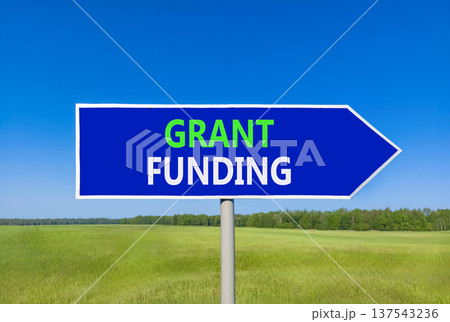 Grant funding symbol. Concept words Grant funding on beautiful blue road sign. Beautiful blue sky green grass field background. Business and grant funding concept. Copy space. Grant funding symbol. Concept words Grant funding on beautiful blue road sign. Beautiful blue sky green grass field background. Business and grant funding concept. Copy space. 137543236