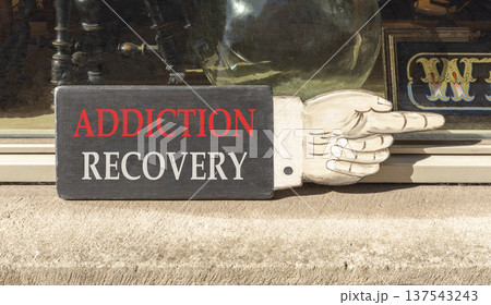 Addiction recovery symbol. Concept words Addiction recovery on beautiful wooden black sign as a hand. Beautiful store display background. Psychology addiction recovery concept. Copy space. Addiction recovery symbol. Concept words Addiction recovery on beautiful wooden black sign as a hand. Beautiful store display background. Psychology addiction recovery concept. Copy space. 137543243