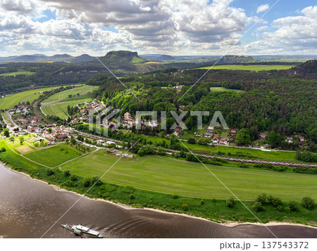 A panoramic, picturesque view of the Elbe River bend in the Saxon Switzerland National Park against a blue cloudy sky. 137543372