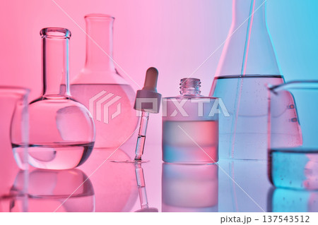 Biotechnology laboratory glassware on reflective surface with dropper 137543512