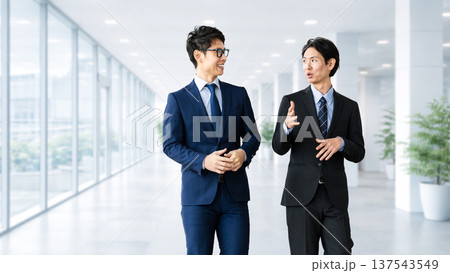 話しながら歩く2人の男性ビジネスマン 137543549